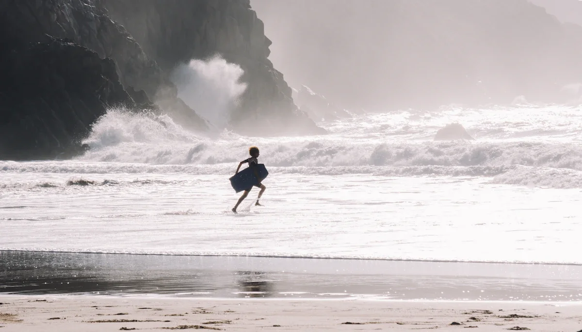 Planche de bodyboard et palmes posées sur le sable