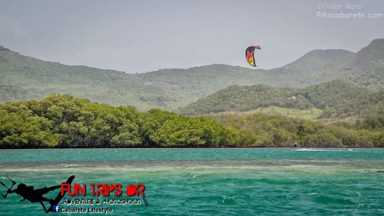 Kitesurfeur sur le lagon d'eau plate de Buen Hombre, mangrove et collines vertes en arrière-plan