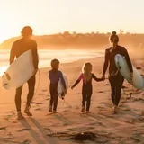 Famille avec enfants pratiquant le surf sur la plage