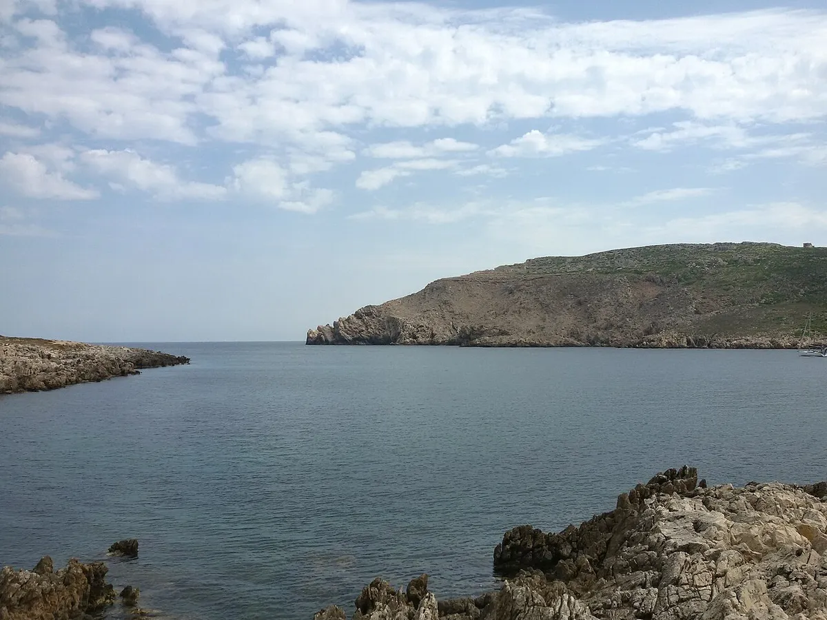 Eau calme à l'entrée de la baie de Fornells, à Minorque, avec la Mola sur la droite