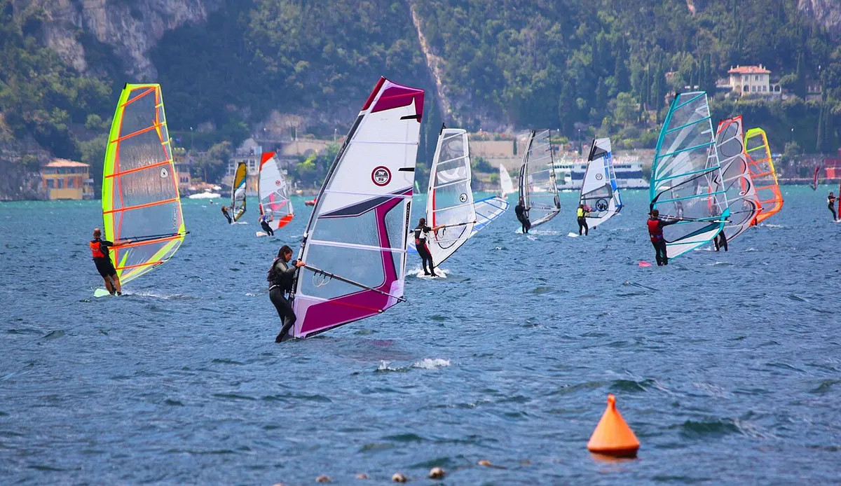 Véliplanchistes sur le lac de Garde devant Torbole, avec une bouée orange au premier plan