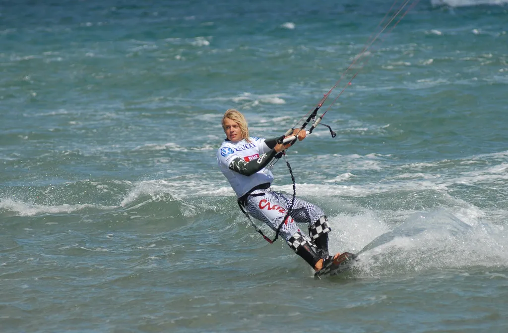 Kitesurfeur filant sur une eau agitée à Leucate, la barre en mains et les lignes tendues vers l'aile