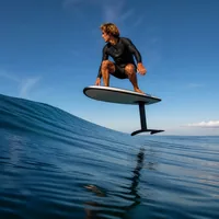 Foileur en position basse volant au-dessus d'une vague