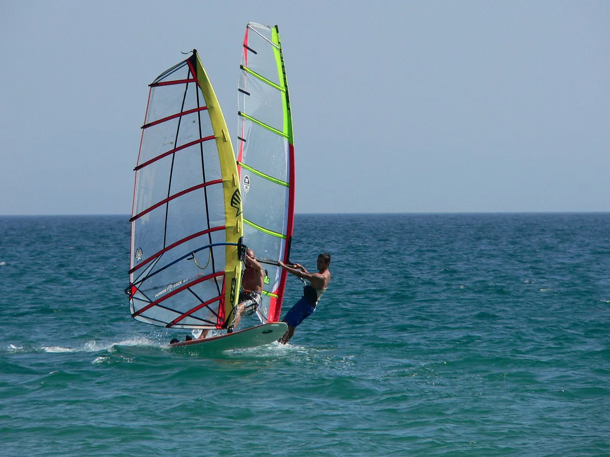 Deux véliplanchistes naviguant très près l'un de l'autre devant la plage de Punta Paloma, à Tarifa