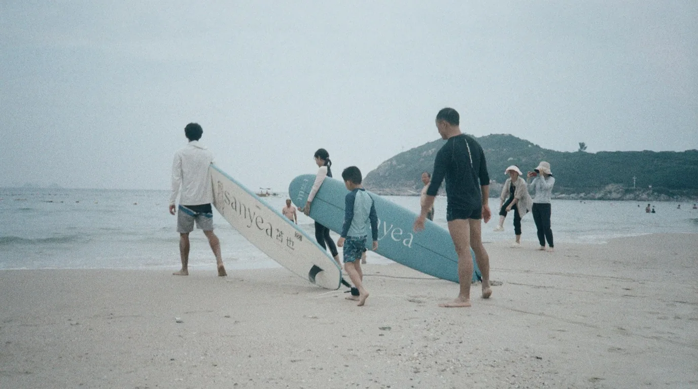 Des adultes et un enfant portent des planches de surf sur une plage