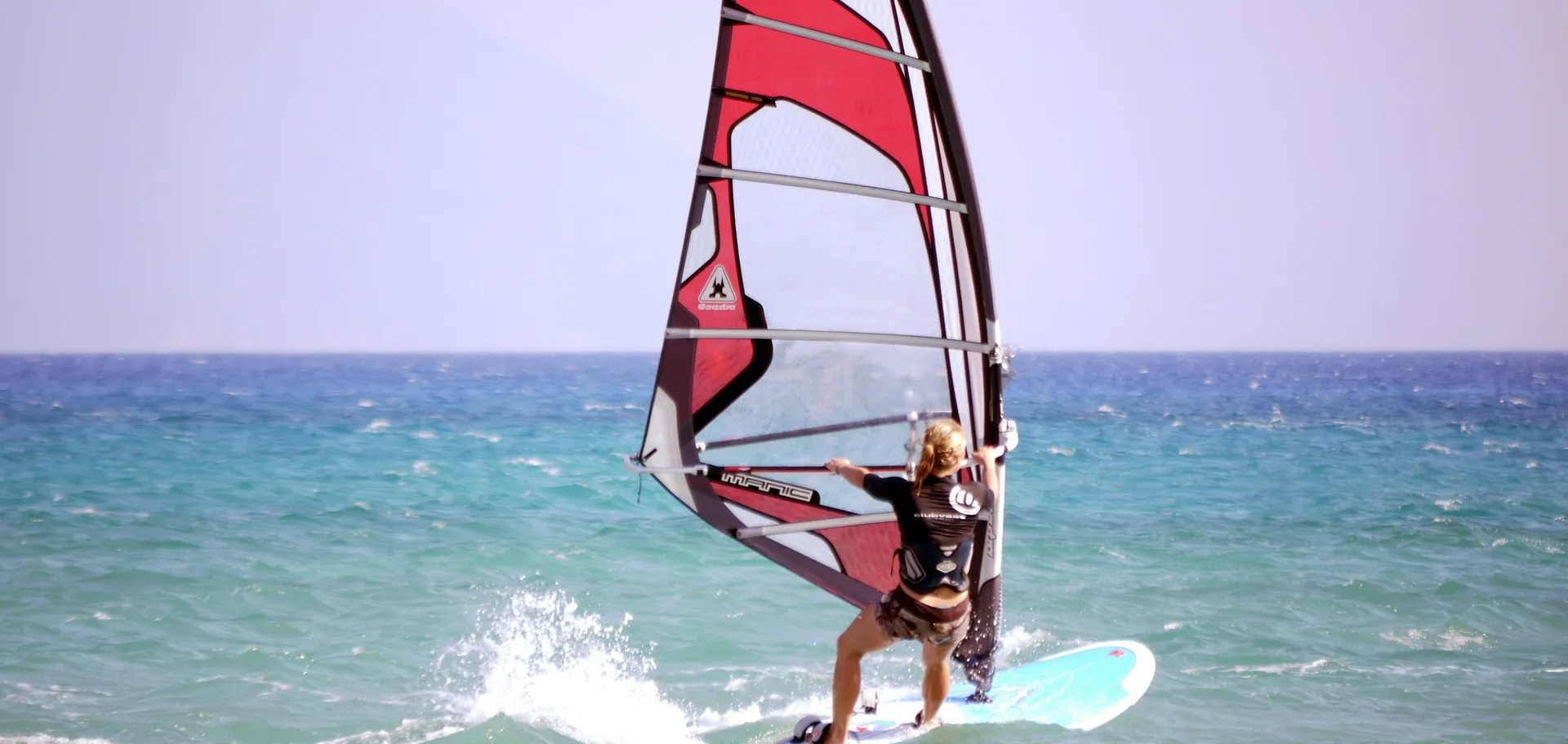 Windsurfeur naviguant sur une mer turquoise