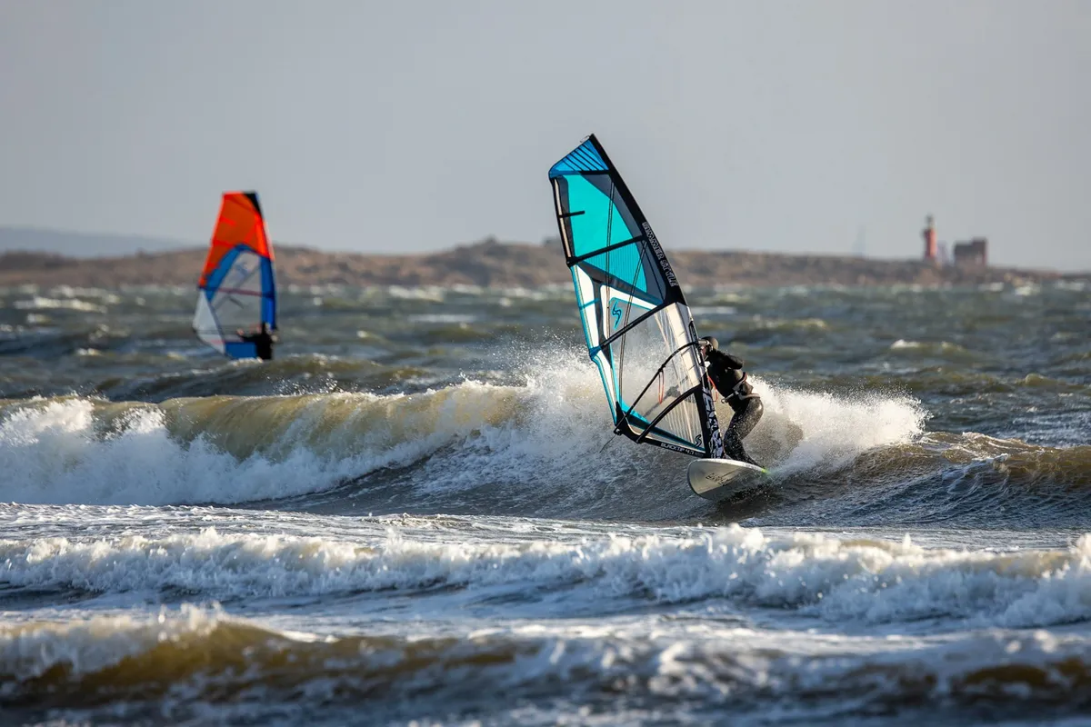 Deux windsurfeurs naviguant dans des vagues déferlantes