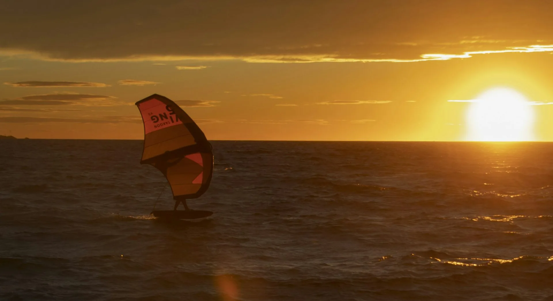 Rider de wing foil au coucher du soleil
